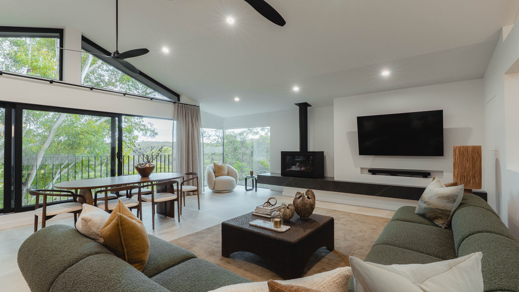 Modern living room with a large TV, sofa, and coffee table.
