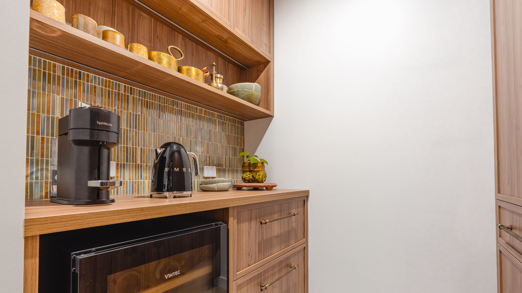Small kitchenette with wooden cabinets, a coffee maker, and a microwave.
