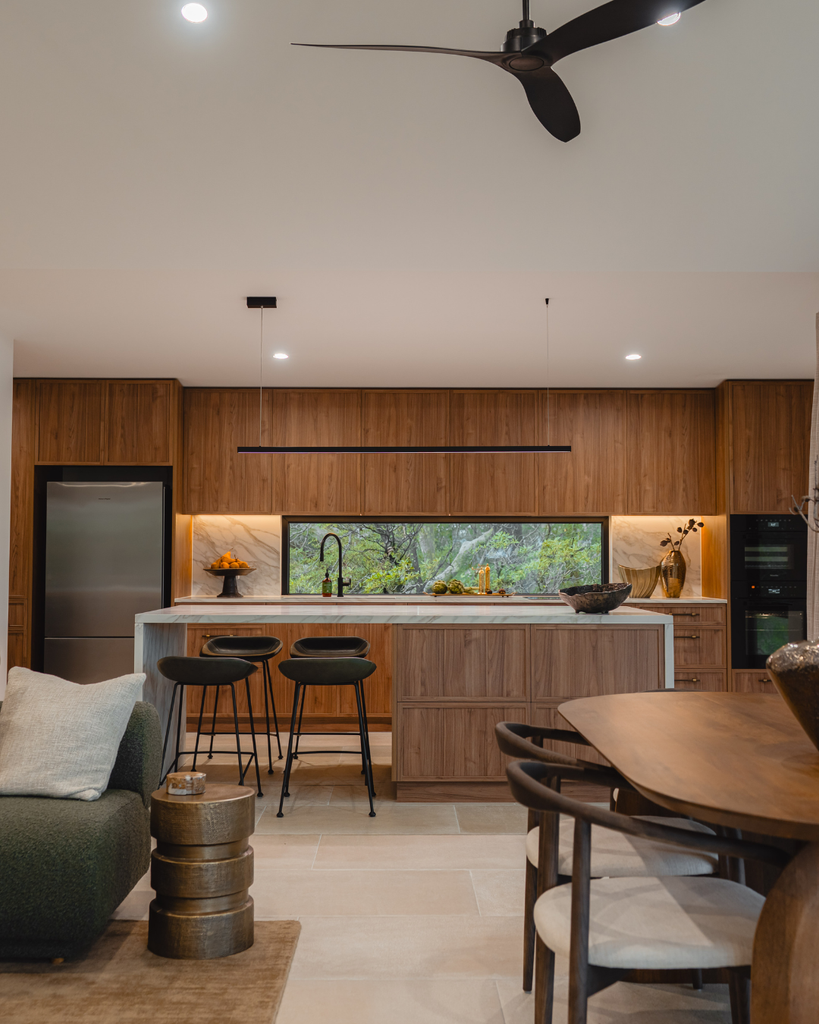 Modern kitchen with wooden cabinets, island, and dining area.