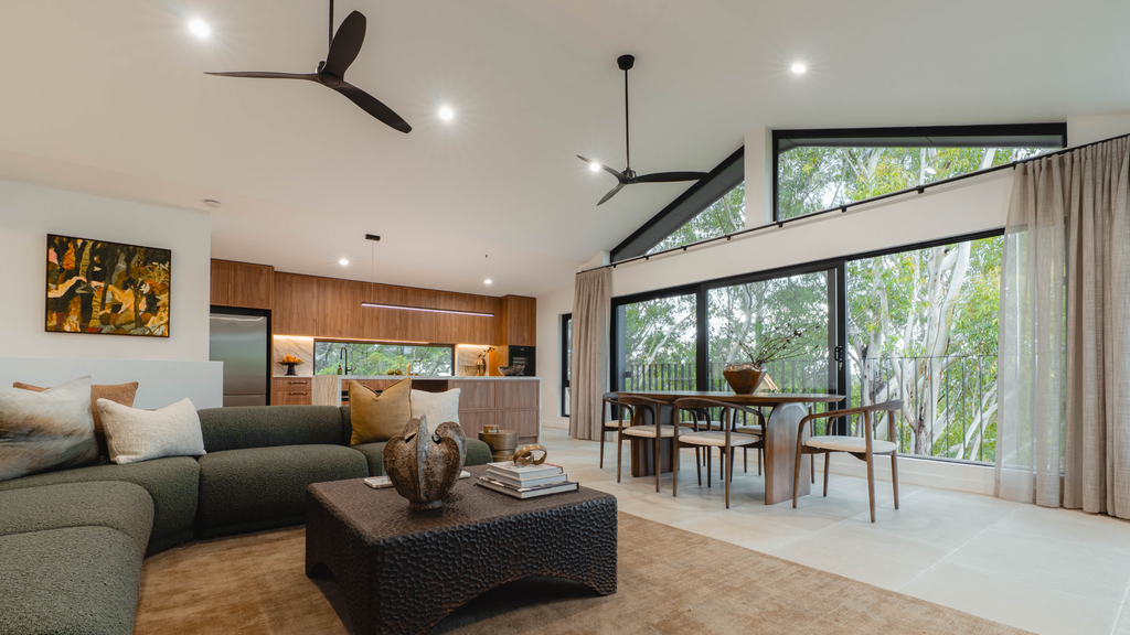 Modern living room with large windows, furniture, and decor.